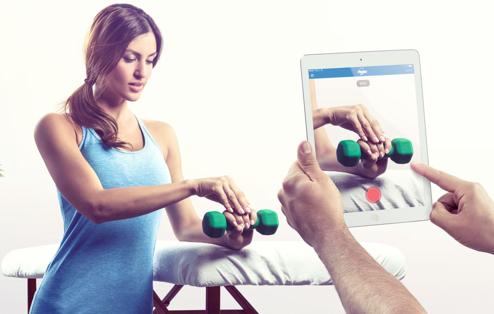 Un physio filme une patiente qui soulève un petit poids avec Phydeo sur une tablette